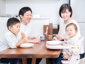 ダイニングテーブルを囲んで笑うご家族四人