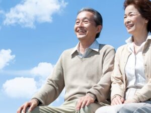 青空を背に並んで笑うご夫婦