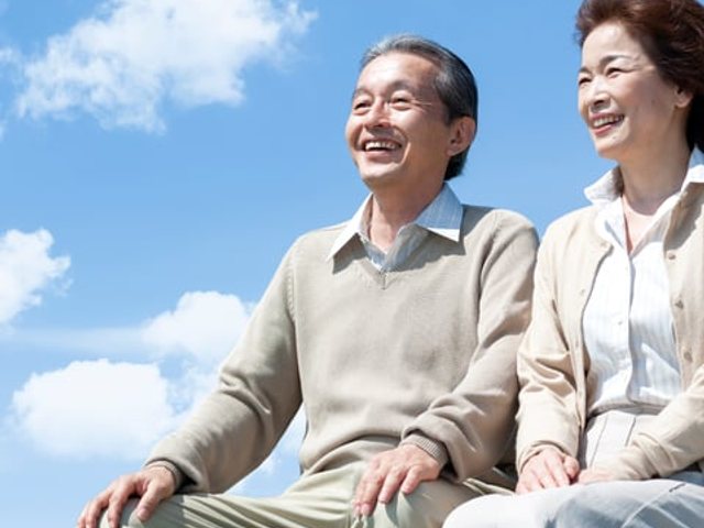 青空を背に並んで笑うご夫婦