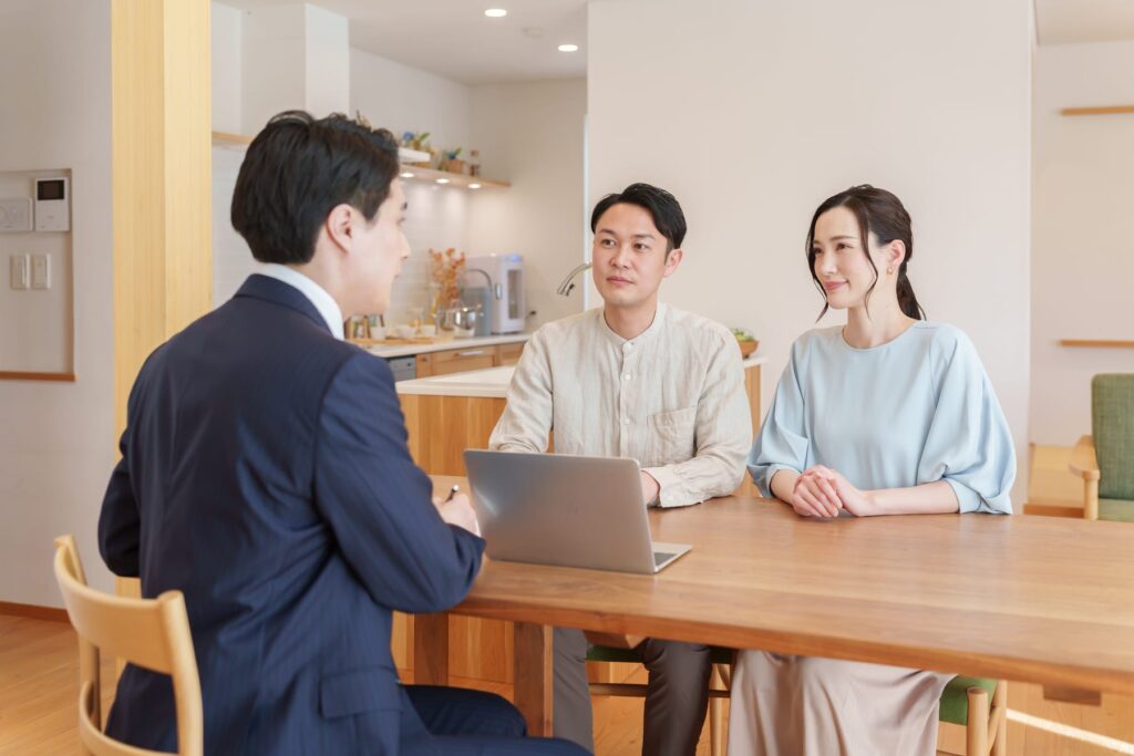 ダイニングテーブルで担当者と向かい合って話すご夫婦