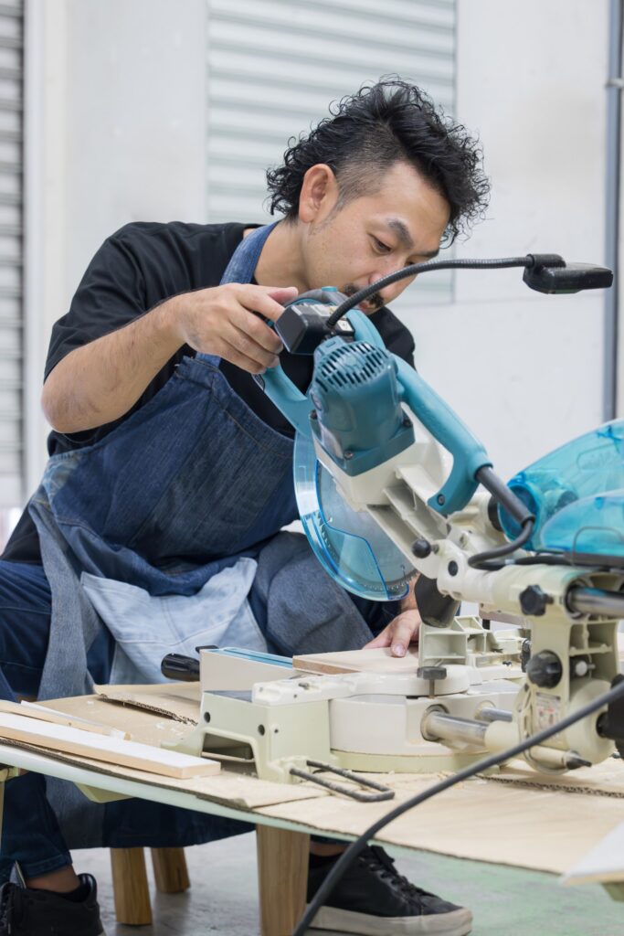 作業台で木材を切る棟梁（デモ）